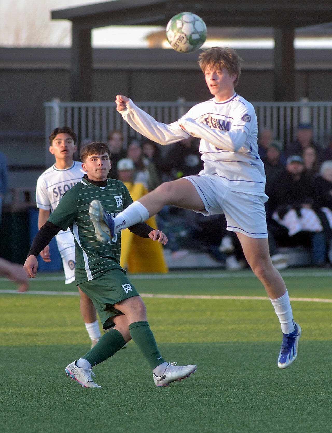 Photo by Keith Thorpe/Olympic Peninsula News Group / Sequims Finn Braaten, front, takes a header as Port Angeles A.J. Martinez keeps watch on April 16 at Peninsula College.