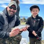 Sequim Gazette photos by Matthew Nash
Bud Tweten proudly holds his 4-year-old son Wyatts first fish he ever caught on April 20. Wyatt was at Kids Fishing Day with his parents, twin brother, older brother and older sister.