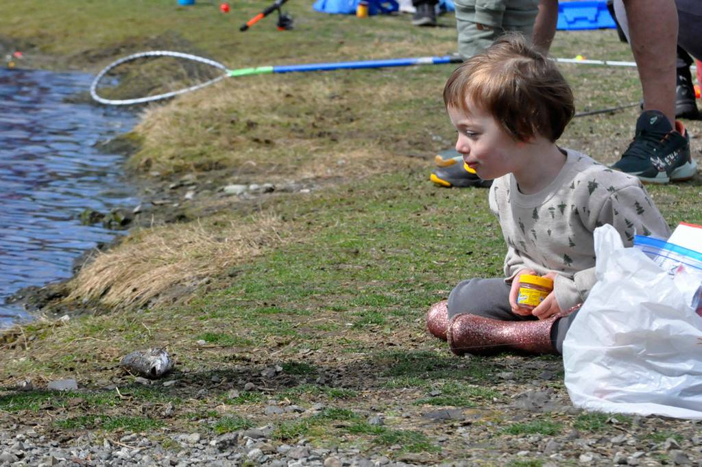 Naomi Victor, 2-and-a-half, of Port Angeles admires her first caught fish during Kids Fishing Day in Carrie Blake Community Park. Her father Raphael said theyve tried fishing many times before but this was their first successful day fishing.