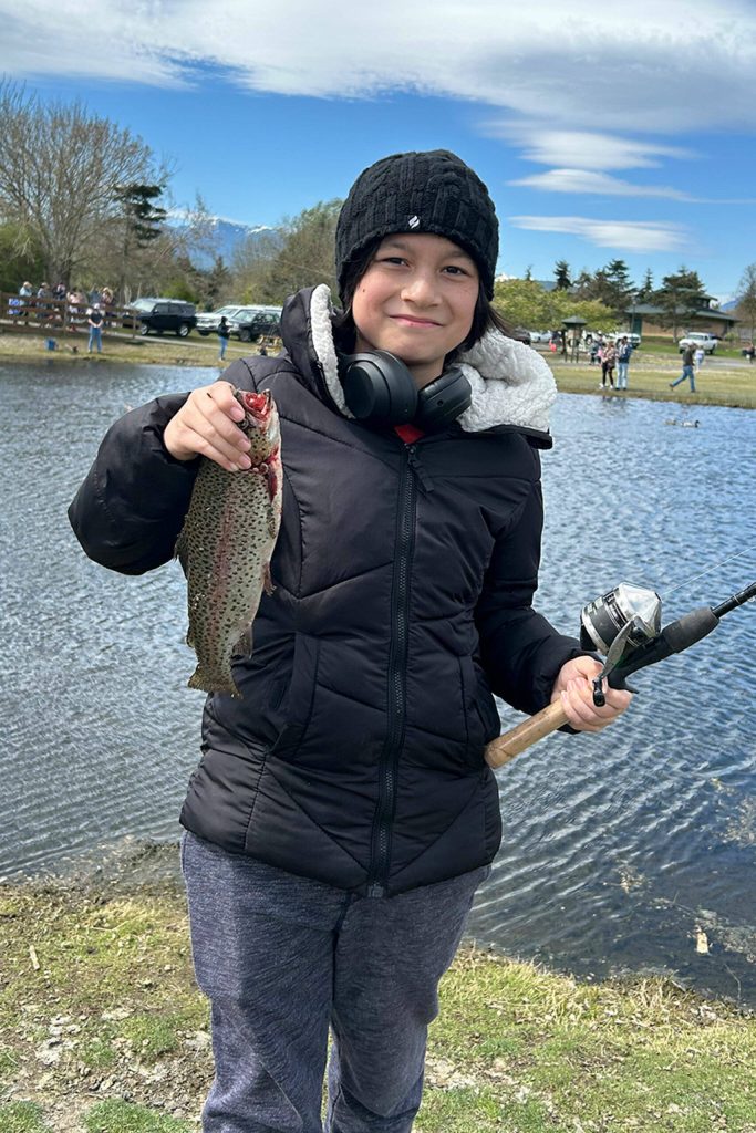 Sequim Gazette photo by Matthew Nash/ Christian Stevenson, 11, of Port Ludlow, holds his second catch of the day on April 20 during Kids Fishing Day.