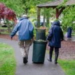 Sequim Gazette photo by Elijah Sussman / Volunteer landscapers carry a barrel of organic material at Carrie Blake Community Park during the Sequim Beautiful Day event on April 27.