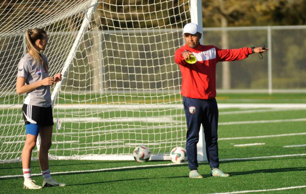 Sequim Gazette photo by Michael Dashiell / North Peninsula Football Club coach Juan Carlos Cisneros explains a drill to Christina Dalton and NPFC players at a practice in Port Angeles on May 7.