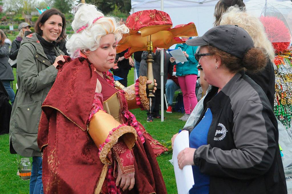 Marissa Meek, wearing You light up my life at the second Trashion Show, speaks with judge Jennifer Rose with Around Again as fellow judge Emily Underwood with Over the Fence looks on. Meek said her mother had some old, unused lamp shades and she loved how decedent they felt. She plans to use the cloak in a film shes making for a class at Peninsula College.