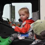 Two-year-old Ozzie Herbert sits in a fire engine courtesy Clallam County Fire District 3 as his dad Teddy watches him.