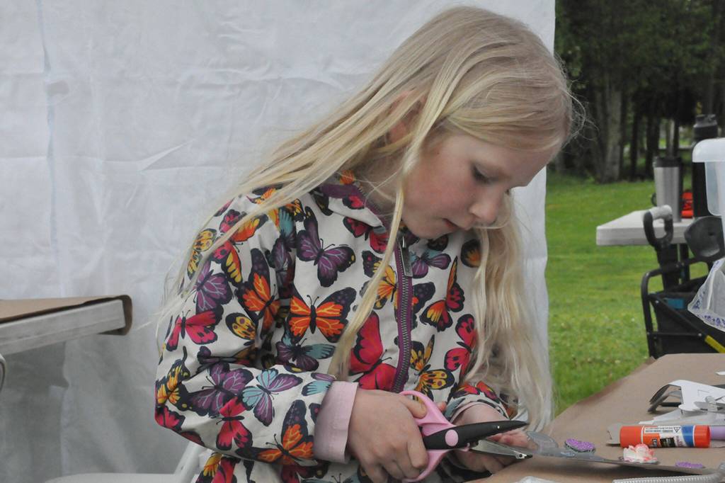 Sequim Gazette photo by Matthew Nash/ Ruby Miller, 6, carefully cuts along the edges of a crown she makes on May 4 during the Sequim Irrigation Festivals Family Fun Days.