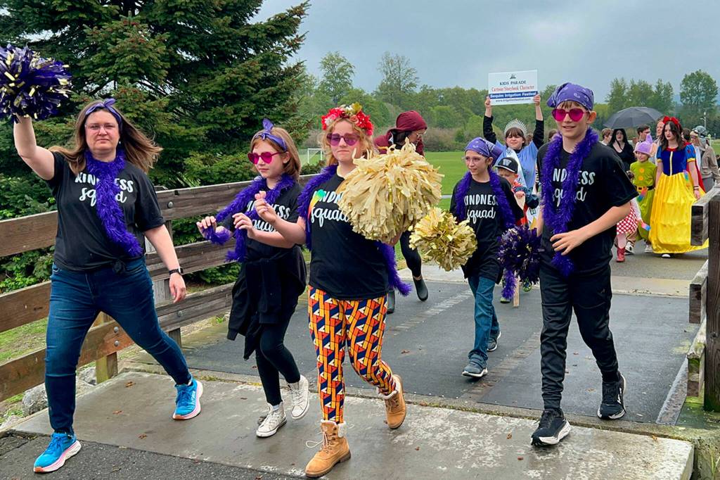 Sequim Gazette photo by Matthew Nash/ Teacher Sarah Castell leads students from the Helen Haller Elementary Kindness Squad in the Kids Parade on May 4.