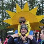 Sequim Gazette photo by Matthew Nash/ Murphy Taylor, 6, brightens up the Kids Parade on May 4 by the Albert Haller Playfields dressed as the sun. He sits on his dad Buddys shoulders as he speaks with festival volunteer Michelle Rhodes. Buddy said Murphy really wanted to be the sun for the event.