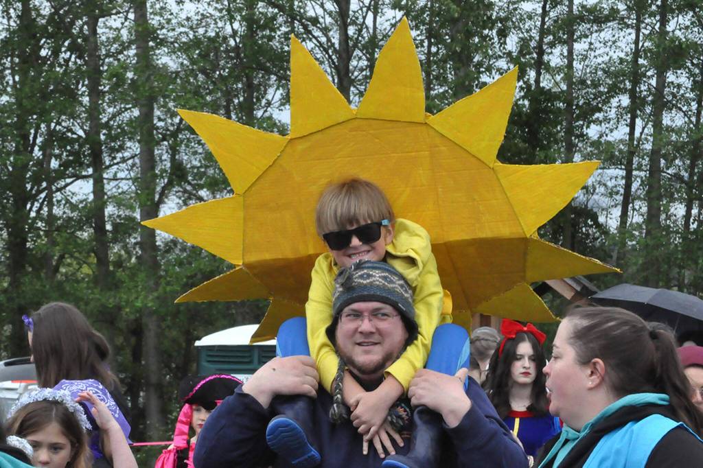 Sequim Gazette photo by Matthew Nash/ Murphy Taylor, 6, brightens up the Kids Parade on May 4 by the Albert Haller Playfields dressed as the sun. He sits on his dad Buddys shoulders as he speaks with festival volunteer Michelle Rhodes. Buddy said Murphy really wanted to be the sun for the event.