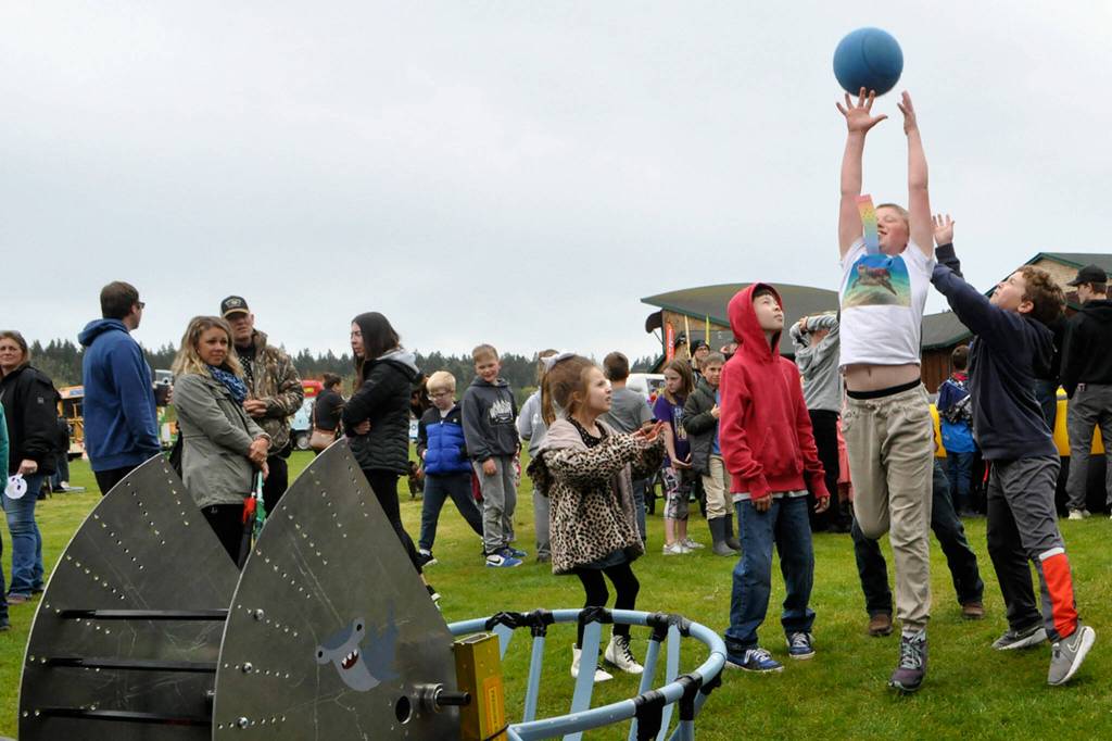 Nine-year-old Thomas Bagley of Sequim extends up to catch a ball from Juggle Jaw, a robot built by the Sequim High Schools Robotics Club. The team made it to district championships this school year, students said.