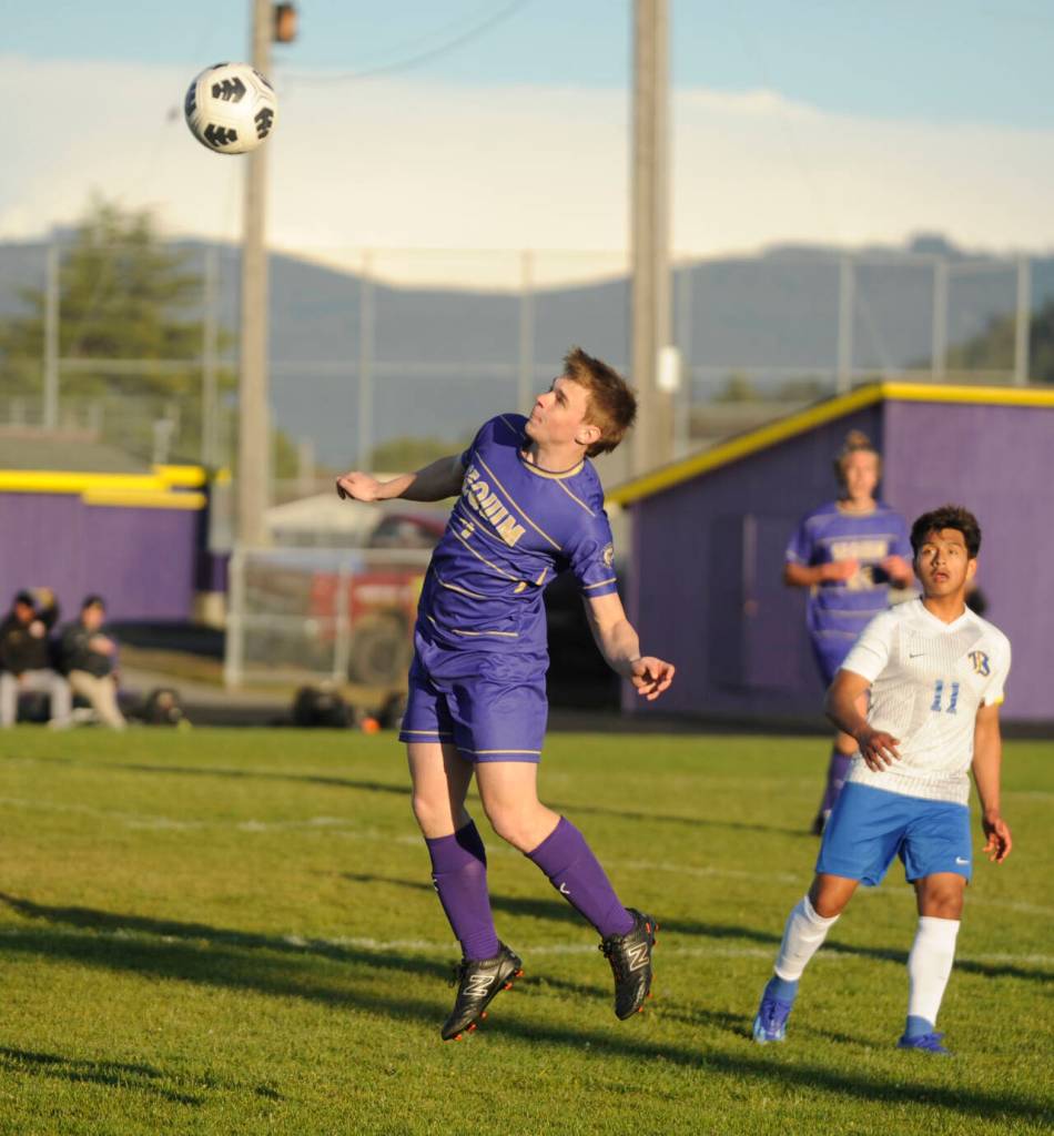 Sequim Gazette photo by Michael Dashiell / Sequims James Mason, left, gets his head on the ball as Bremertons Jerry Santos-Retes looks on, in an Olympic League match-up in Sequim on April 30.