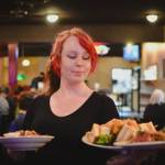 Sequim Gazette photo by Elijah Sussman / Server Amber Melcer delivers a sandwich with tater tots, and a salad at The Oasis Bar and Grill in Sequim on May 5.
