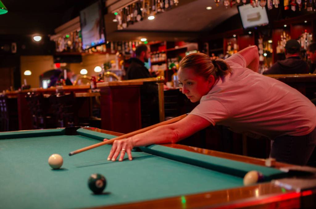 Sequim Gazette photo by Elijah Sussman / Angie Lanum focuses on her shot. She visits from Shelton to see her uncle and compete with him at pool.