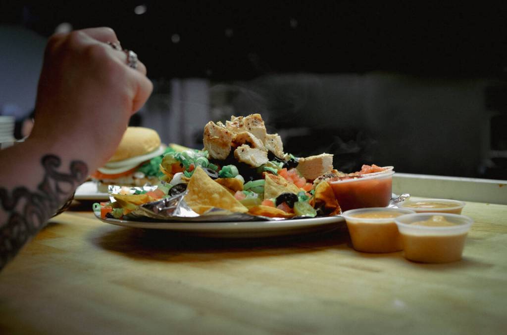 Sequim Gazette photo by Elijah Sussman / Waitstaff collects steaming-hot orders through the servery window at The Oasis Bar and Grill in Sequim on May 5.