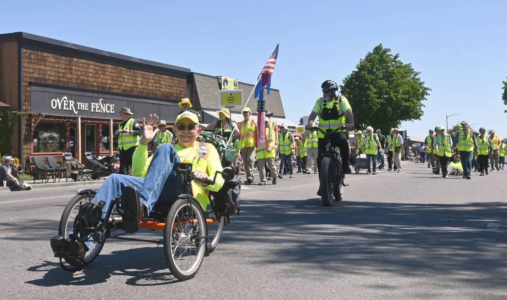 Sequim Gazette photo by Michael Dashiell / John Viada, left, helps lead the Community Emergency Response Team (CERT) entry in the Sequim Irrigation Festival Grand Parade on Saturday.
