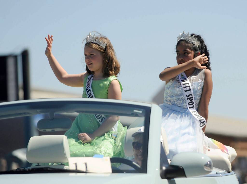 Sequim Gazette photo by Michael Dashiell / Junior Royalty Ruby Sly-Hobson, left, and Dulce Villegas wave to the crowd at the Sequim Irrigation Festival Grand Parade Saturday afternoon.
