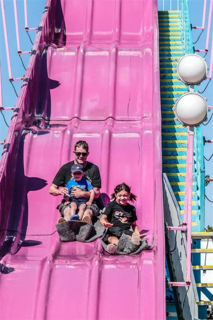 Photo by Bob Lampert
Mike Cox, with children Weston and Gabby, from Port Angeles, enjoy a super slide at the annual Sequim Logging Show last week.
