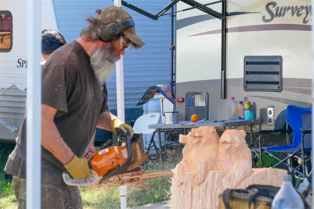Photo by Bob Lampert / Donald Benson of Yelm is busy cutting into his newest wildlife creation at the Sequim Logging Show last week.