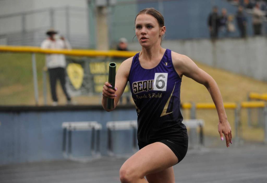 Sequim Gazette photo by Michael Dashiell / Sequim junior Ivy Barrett helps Sequims 4x400 relay team earn a state meet berth at the West Central B-district meet event in Belfair on May 18.