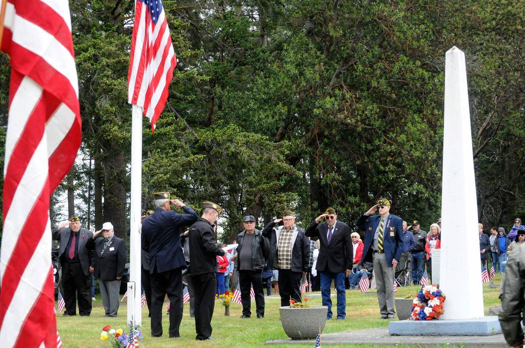 Sequim Gazette photo by Matthew Nash/ Members of the Veterans of Foreign War Post 4760 and American Legion Jack Grennan Post 62 give a silent salute during a Memorial Day ceremony on May 27 in Sequim View Cemetery honoring those lost while serving in the U.S. armed forces.