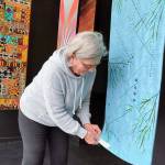 Photo courtesy of Peninsula Fiber Artists 
Port Townsend artist Sue Gale hangs one of the 16 x 60-inch banners now on display in the Peninsula Fiber Artists Fiber Habit walk-by exhibit at 675 Tyler St., Port Townsend. Most pieces in the exhibit are available for purchase directly from the artists.