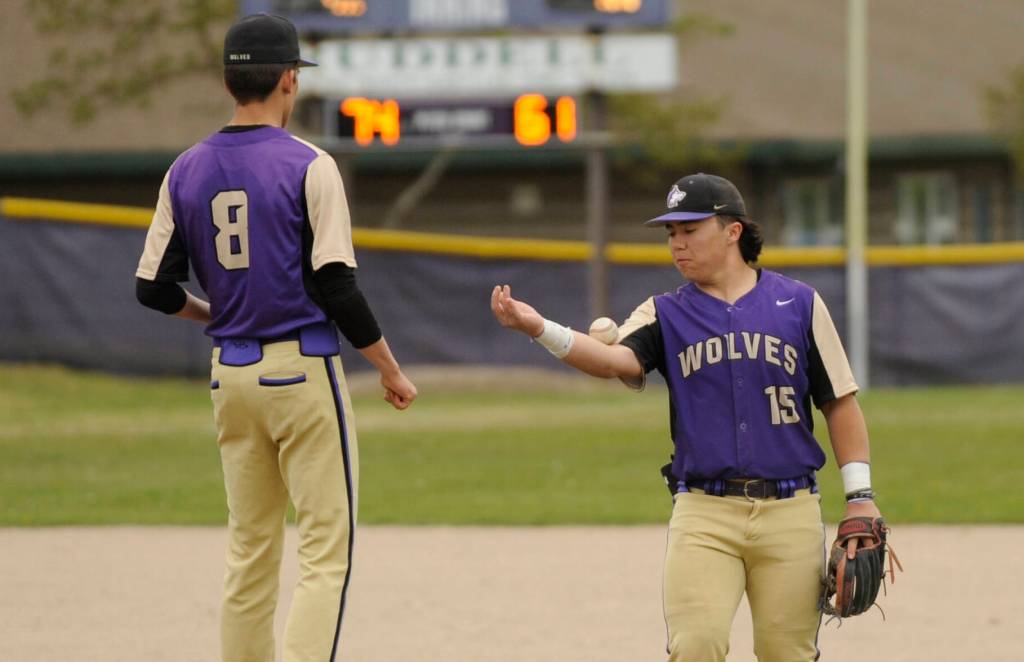 Sequim Gazette photo by Michael Dashiell / Sequim third baseman Ayden Holland, right, bounces the ball to his pitcher Ethan Staples in between innings of an April 24 league match-up with North Mason. Holland was named to the all-Olympic League second team.