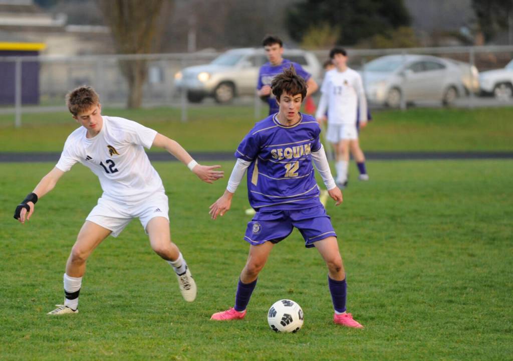 Sequim Gazette photo by Michael Dashiell / Sequims Joshua Alcaraz, center, tries to keep possession as in an Olympic League game against Bainbridge on March 26, was named to the all-Olympic League first team.