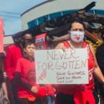 Sequim Gazette photo by Elijah Sussman / Arlene Pebbles Wheeler marches from the Elwha Cultural Heritage Center with a sign reading Never Forgotten on May 3.