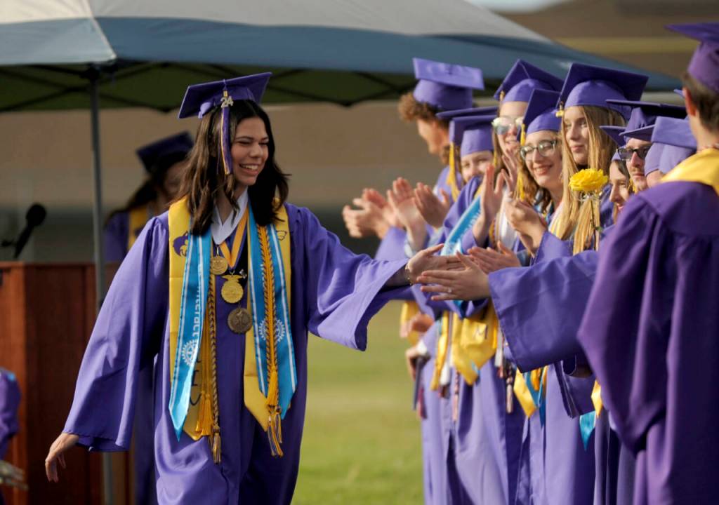 Sequim Gazette photo by Michael Dashiell / Graduating Sequim High senior Emily Post, gets high-fives from classmates at the 2024 Sequim High School graduation ceremony on June 14.