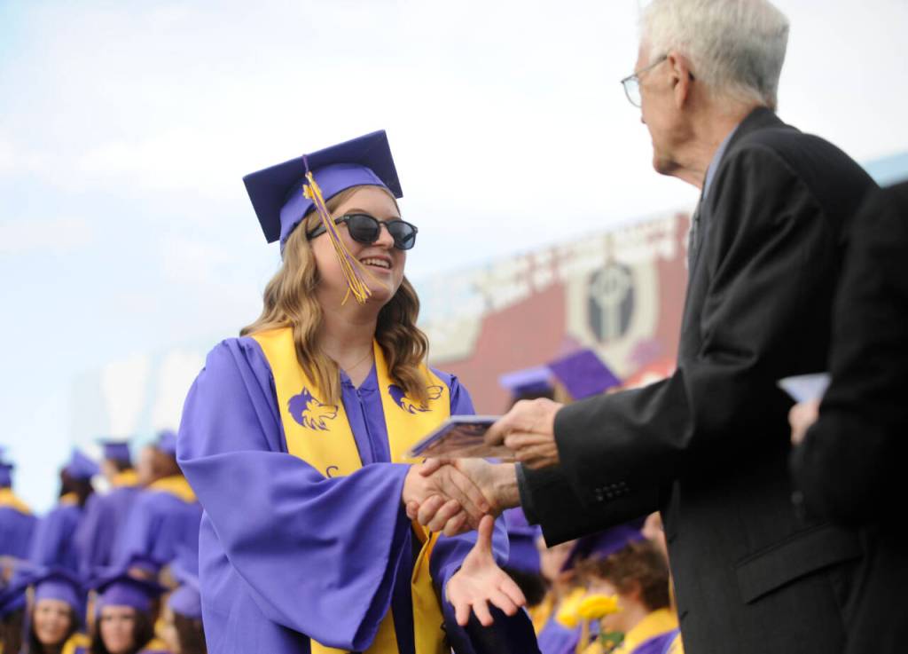 Sequim Gazette photo by Michael Dashiell / Staff-elected speaker Charley Sturm accepts her diploma from Sequim School Board director Larry Jeffryes at the Sequim High School graduation ceremony on June 14.