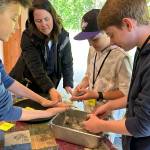 Sequim Gazette photo by Matthew Nash/ Anderson Williams, parent volunteer Kelsey Horst, Connor Horst, and Jack Ross work together to make wildflower seed ball bombs to place around the Dungeness River Nature Center during a field trip for Sequim Middle School sixth grade science classes.