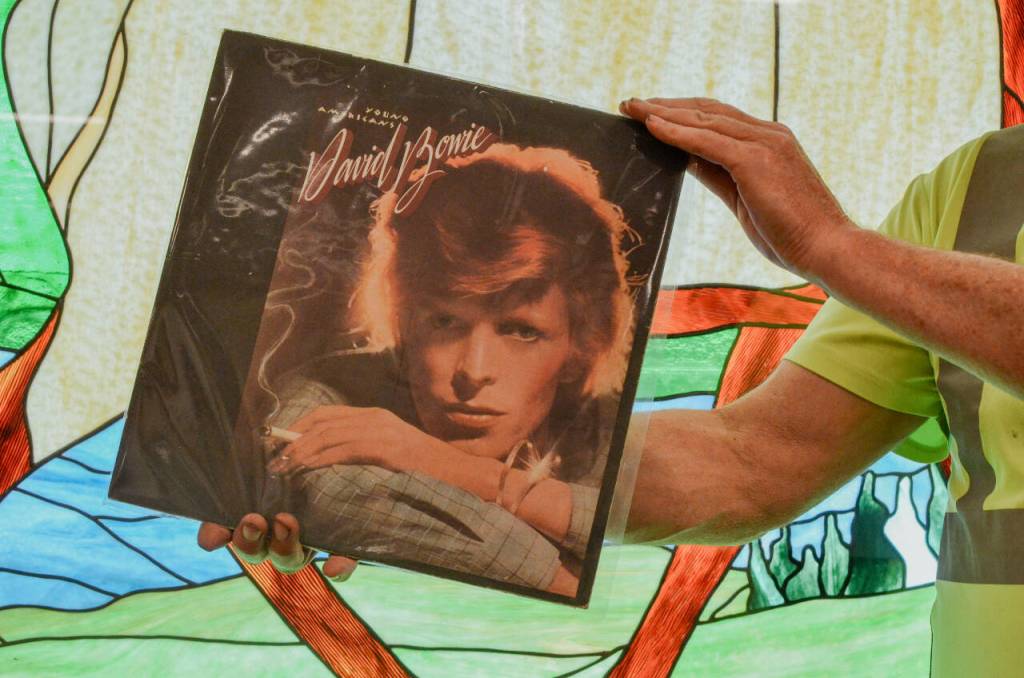 Sequim Gazette photo by Elijah Sussman / Gary Butler frames his copy of David Bowies Young Americans at The Guy Cole Center on May 30.