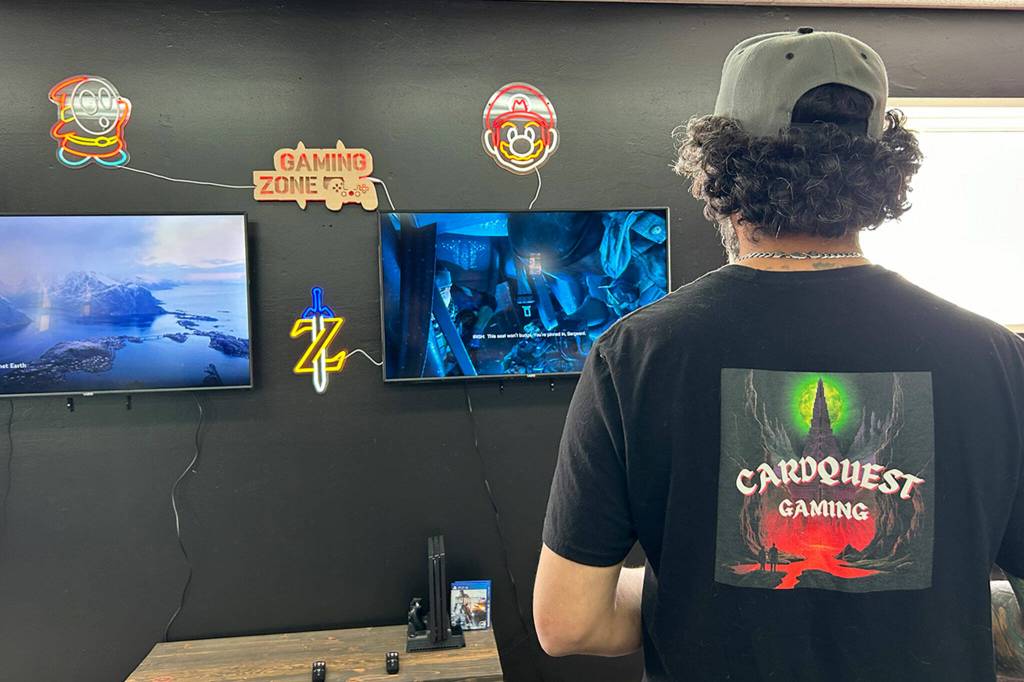 Douglas Offenheiser loads up a video game in Cardquest Gamings video game area. Customers can rent console time to play video games on an array of consoles.