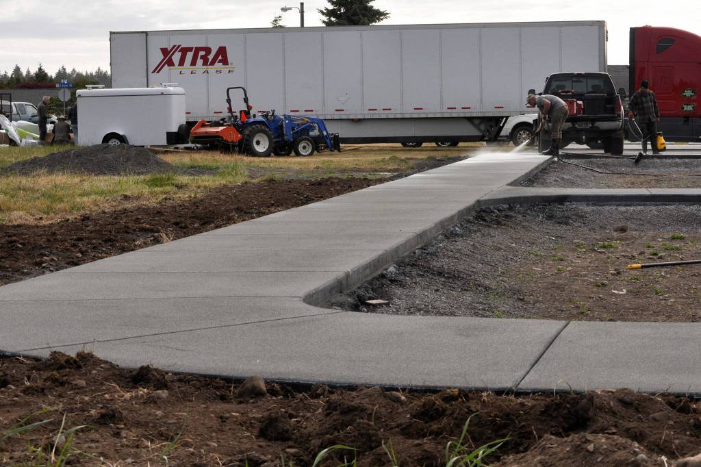 Sequim Gazette photo by Matthew Nash/ Rossi Construction workers acid wash the concrete surfaces at Olympic View Churchs The Gathering Ground on June 12.