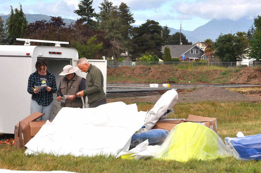 Sequim Gazette photo by Matthew Nash/ Volunteers Kait Saffold, Warren McMasters and Phil Milliman catalogue nuts and bolts for The Gathering Ground playground on June 12. The inclusive playground features equipment that children of all abilities can play on.
