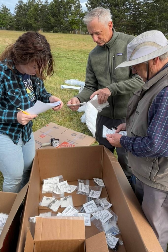 Sequim Gazette photo by Matthew Nash
Volunteers Kait Saffold, Phil Milliman and Warren McMasters catalogue nuts and bolts for The Gathering Ground playground on June 12. The inclusive playground features equipment that children of all abilities can use.