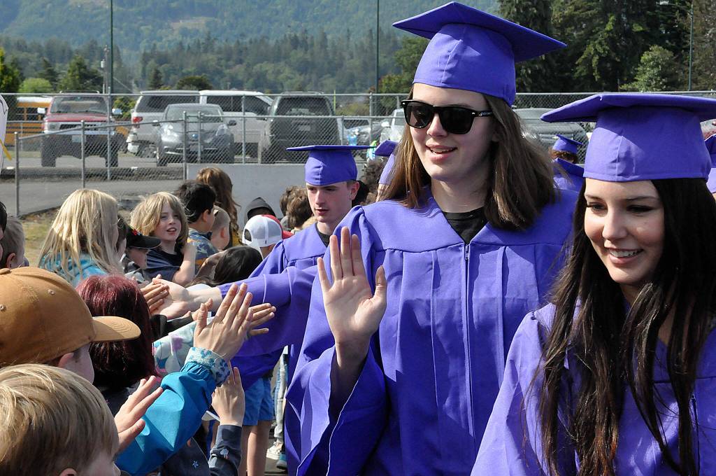 Sequim Gazette photo by Matthew Nash/ Sequim High seniors Dani Herman and Ava Welch high-five and give hellos to students during the annual SHS Grad Walk.