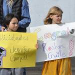 Sequim Gazette photo by Matthew Nash/ First graders Caden Reyes and Hazel Griffith await Sequim High seniors coming around for high-fives and hellos during the SHS Grad Walk.