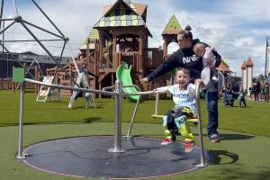 KEITH THORPE/PENINSULA DAILY NEWS
Three-year-old Archie Hanson takes a spin on a merry-go-round pushed by his mother, Justine Hanson of Port Angeles, with sister Arlene Hanson 7 months, during Sunday's grand reopening of the Dream Playground at Erickson Playfield in Port Angeles. The playground was rebuilt earlier this month by volunteers after an arson fire destroyed much of the playground equipment in December. Although there are still details to attend to and minor adjustments to be made, the facility will be open daily from dawn until dusk.