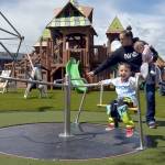 Photo by Keith Thorpe/Olympic Peninsula News Group
Three-year-old Archie Hanson takes a spin on a merry-go-round pushed by his mother, Justine Hanson of Port Angeles, with sister Arlene Hanson 7 months, during the grand reopening of the Dream Playground at Erickson Playfield in Port Angeles on June 16. The playground was rebuilt earlier this month by volunteers after an arson fire destroyed much of the playground equipment in December. Although there are still details to attend to and minor adjustments to be made, the facility will be open daily from dawn until dusk.