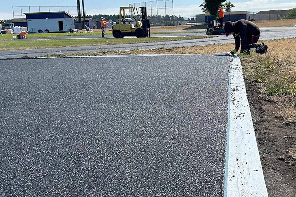 Sequim Gazette photo by Matthew Nash
Ryan Cortes with Beynon Sports fine tunes material recently placed around the Sequim School District track on July 19.