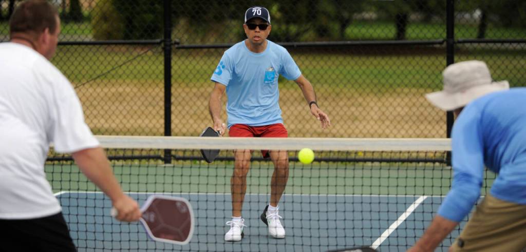Sequim Gazette photo by Michael Dashiell / Yiu Fun Derek Lee, background, and partner Davin Lee (not pictured) take on Brian Wetzler and Ronald Hopkins in a mens doubles 3.0 division match at the Sequim Fling Pickleball Tournament on June 29.