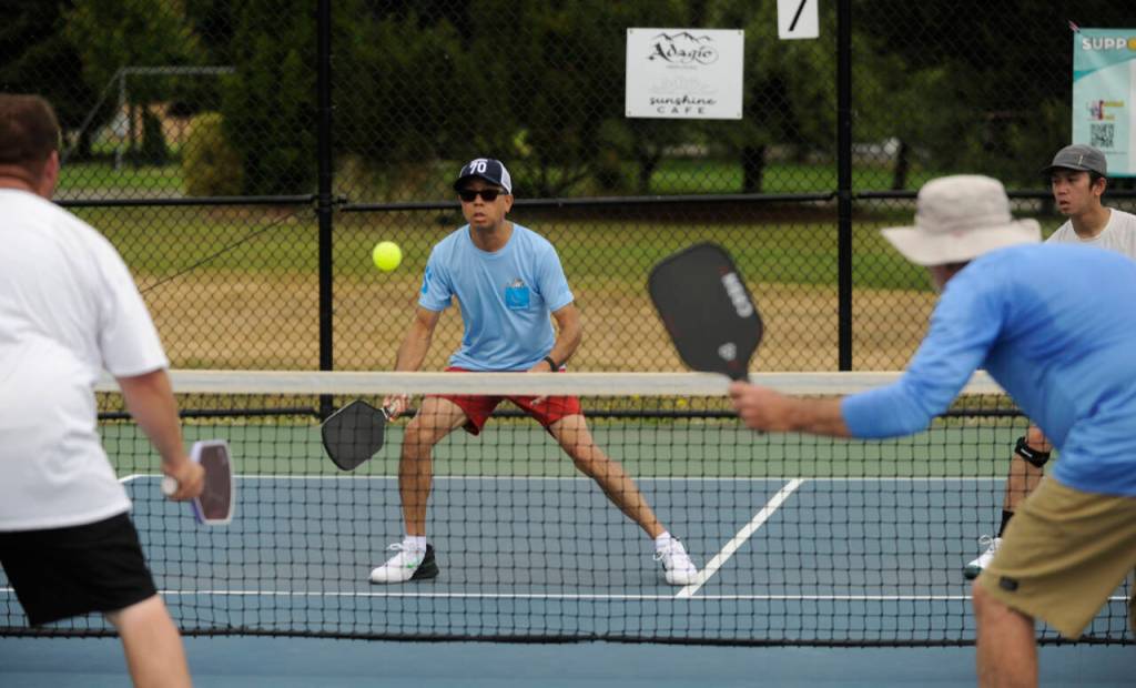 Sequim Gazette photo by Michael Dashiell / In background, Yiu Fun Derek Lee, left, and partner Davin Lee take on Ronald Hopkins (foreground, left) and Brian Wetzler in the mens doubles 3.0 division gold medal match at the Sequim Fling Pickleball Tournament on June 29. Hopkins and Wetzler won the match to take top honors in the division.