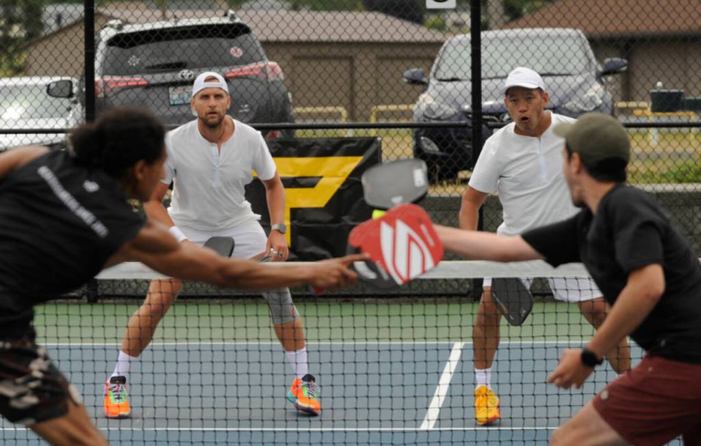 Sequim Gazette photo by Michael Dashiell / In background, Ryan Phasouk (left) and Mike Jelinek take on Moe Hussein Ahmed and Jon Olson in the gold medal match of the mens doubles 4.0+ division of the Sequim Fling Pickleball Tournament on June 29.