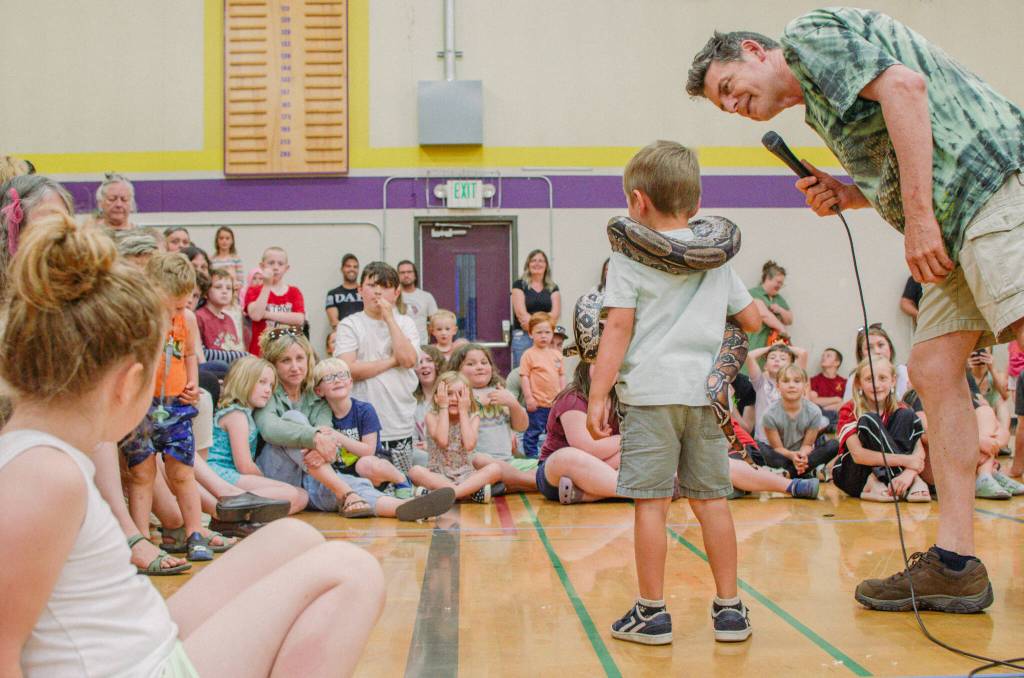 Sequim Gazette photo by Elijah Sussman / Arlo Svik faces audience while draped with constrictor.