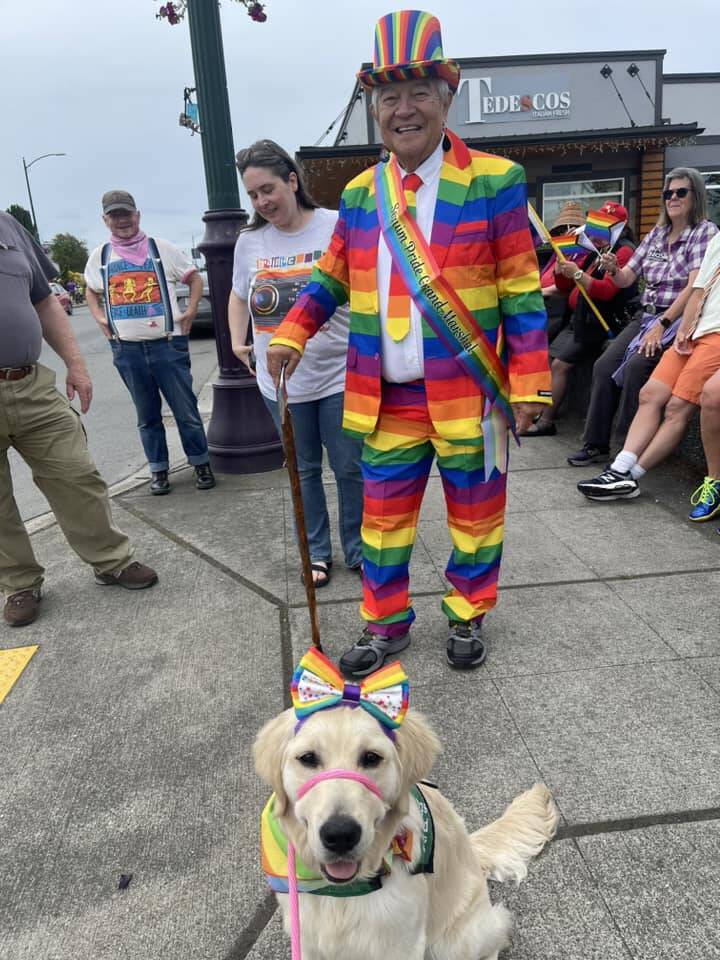 Photo courtesy Barbara Surber/ Michael Lowe stands by Nuala, a puppy being raised by Barbara Surber of Sequim for the Sequim Puppy Raisers with Guide Dogs for the Blind, during the Sequim Pride march on June 29.