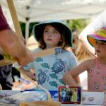 Sequim Gazette photos by Michael Dashiell
At left, Sophia Arbuckle, 9, and Grace Kirn, 7, both of Port Townsend, learn about craft stick bending from Sequims Brad Griffith at the Toy Makers Teacher booth during the City of Sequims 2024 Independence Day Celebration at Carrie Blake Community Park on July 4.