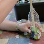 Sequim Gazette photo by Elijah Sussman / Eden Voebel demonstrates plastic compression for eco-brick on June 26.