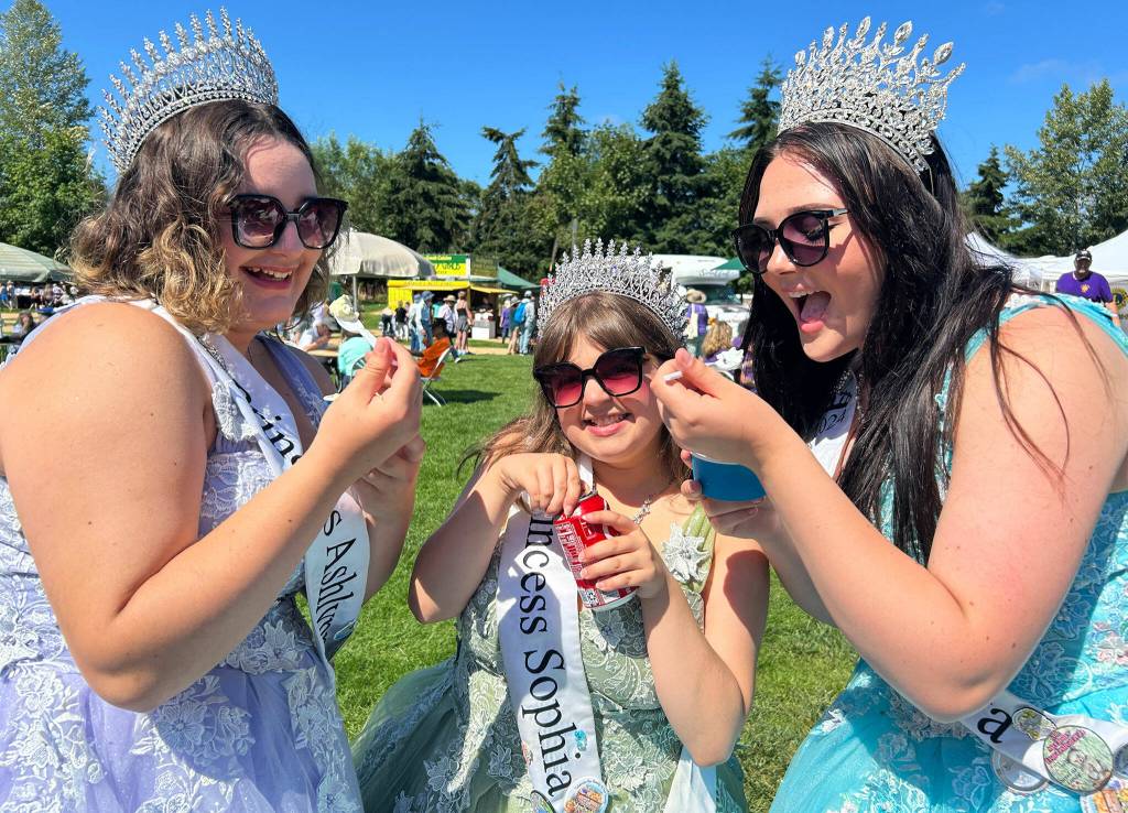 Sequim Gazette photo by Matthew Nash/ Sequim irrigation Festival royalty, from left, princess Ashlynn Northaven, princess Sophia Treece, and queen Ariya Goettling enjoy some treats after celebrating the opening of the Sequim Lavender Festival on July 19.