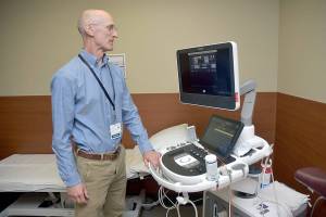 Olympic Medical Heart Center director Leonard Anderson examines a new echocardiograph at the Port Angeles hospital facility. (Keith Thorpe/Peninsula Daily News)