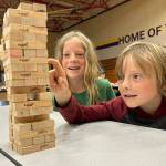 Sequim Gazette photo by Matthew Nash/ Journey, 7, and Fenn, 10, Maynard plan their next moves in a game of Jenga during the Sequim Librarys Discovery Club program on July 18 in the Olympic Peninsula Academy gym.